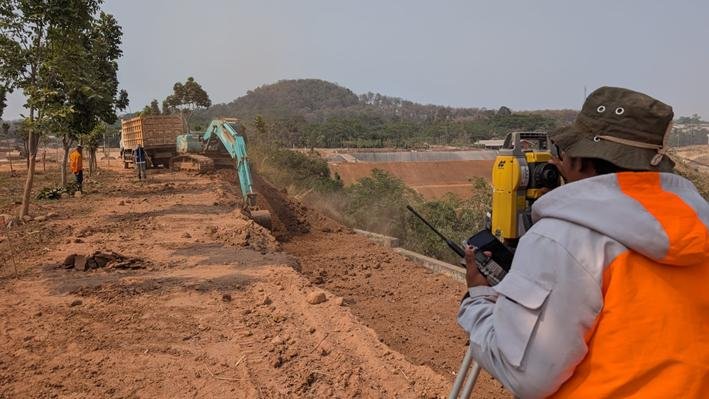 Surveyor total station memantau pekerjaan tanah rehabilitasi lereng di Batang